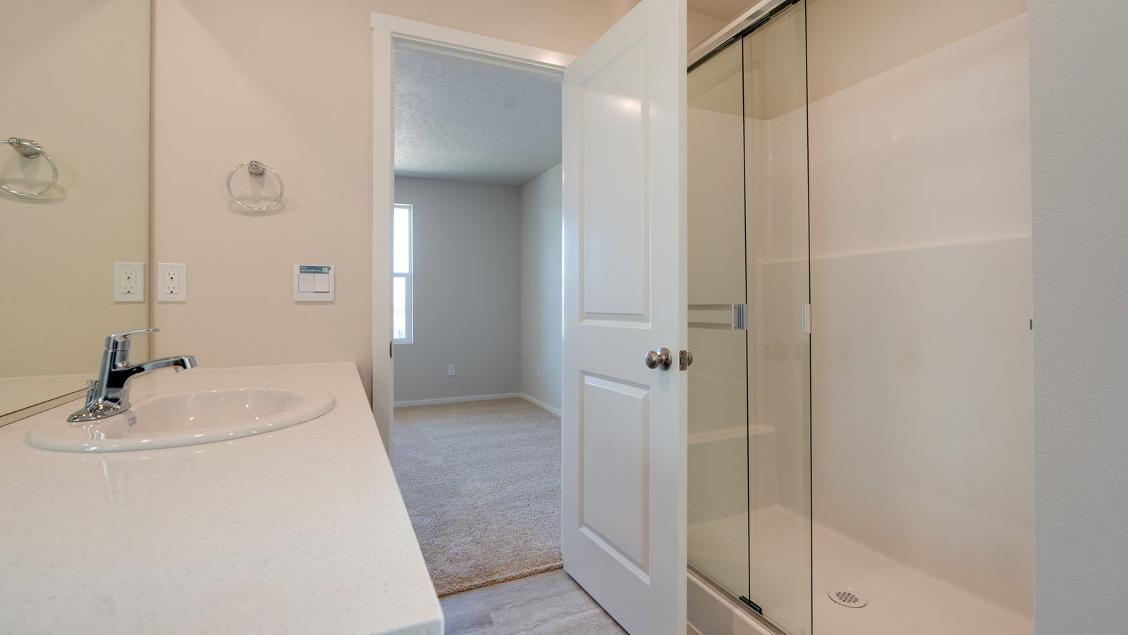 Primary bathroom with quartz counters and a walk-in shower