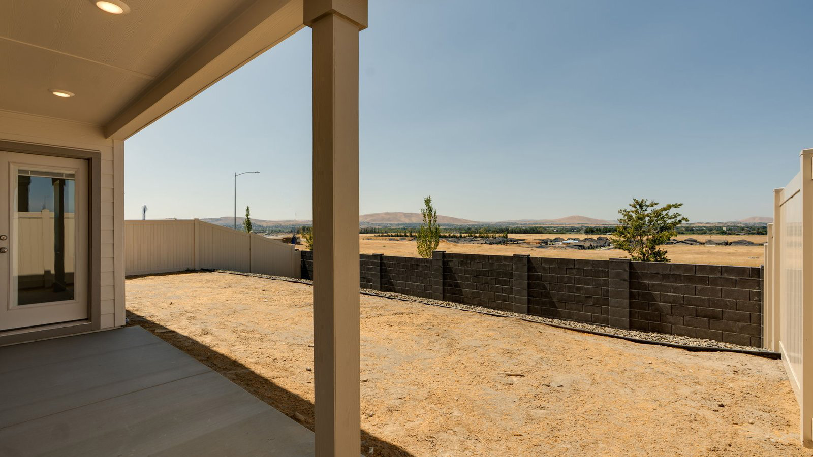 backyard with vinyl plank fence and covered patio