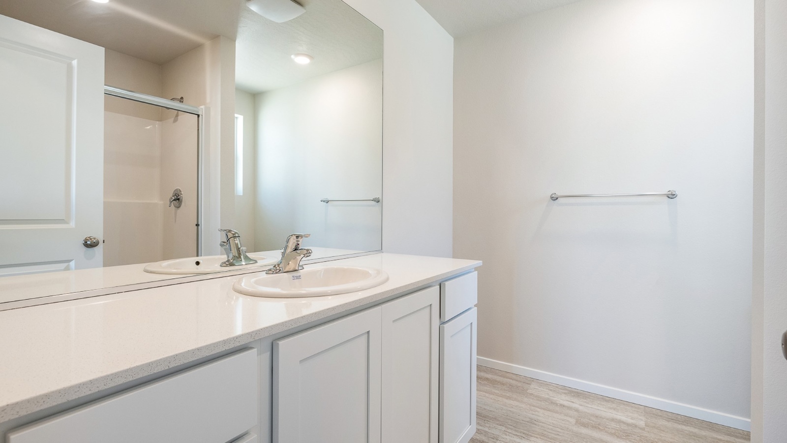 Primary bathroom with quartz counters and a walk-in shower