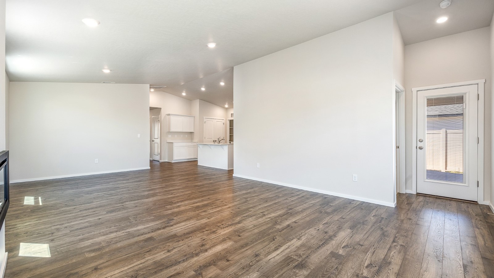 Great room with laminate flooring and an electric fireplace and vaulted ceilings