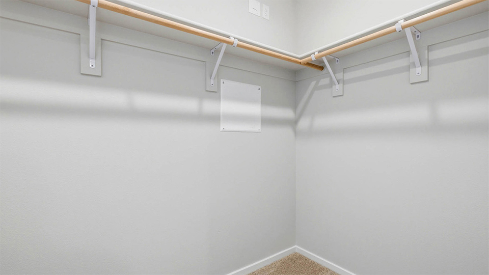 Primary bedroom walk-in closet with built-in shelves