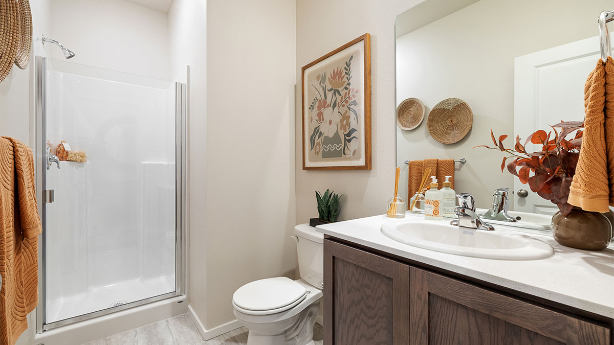 Main floor bathroom with quartz counters and a walk-in shower