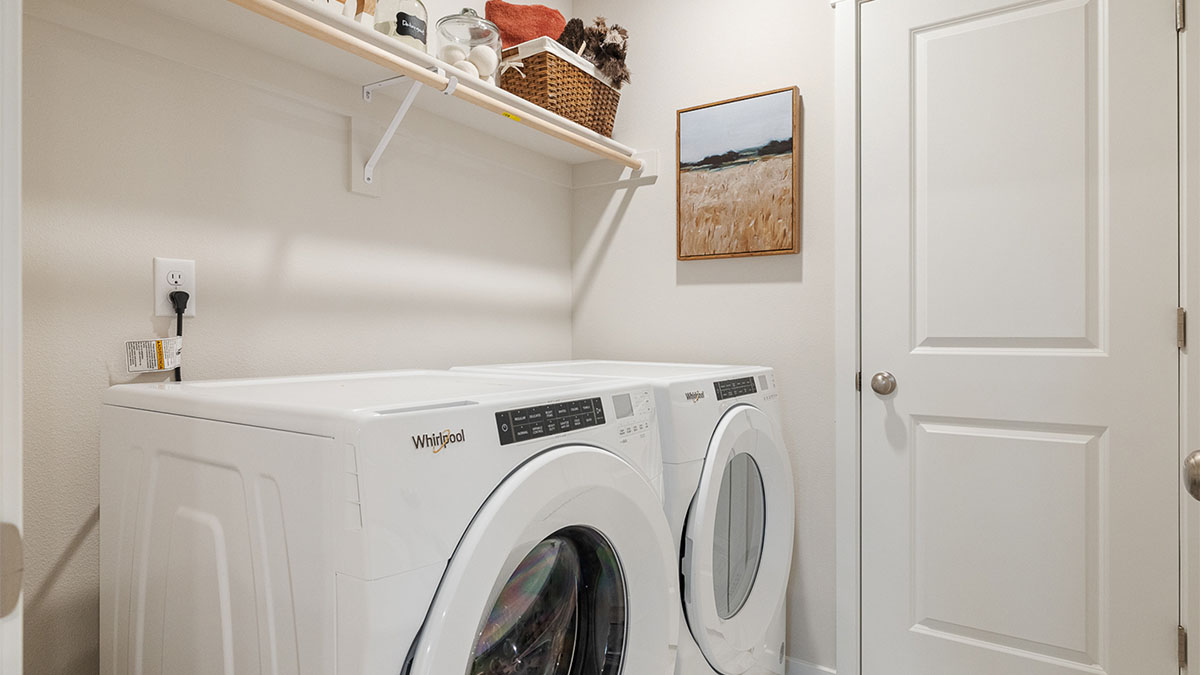 Laundry room with built-in shelves and washer and dryer hookups
