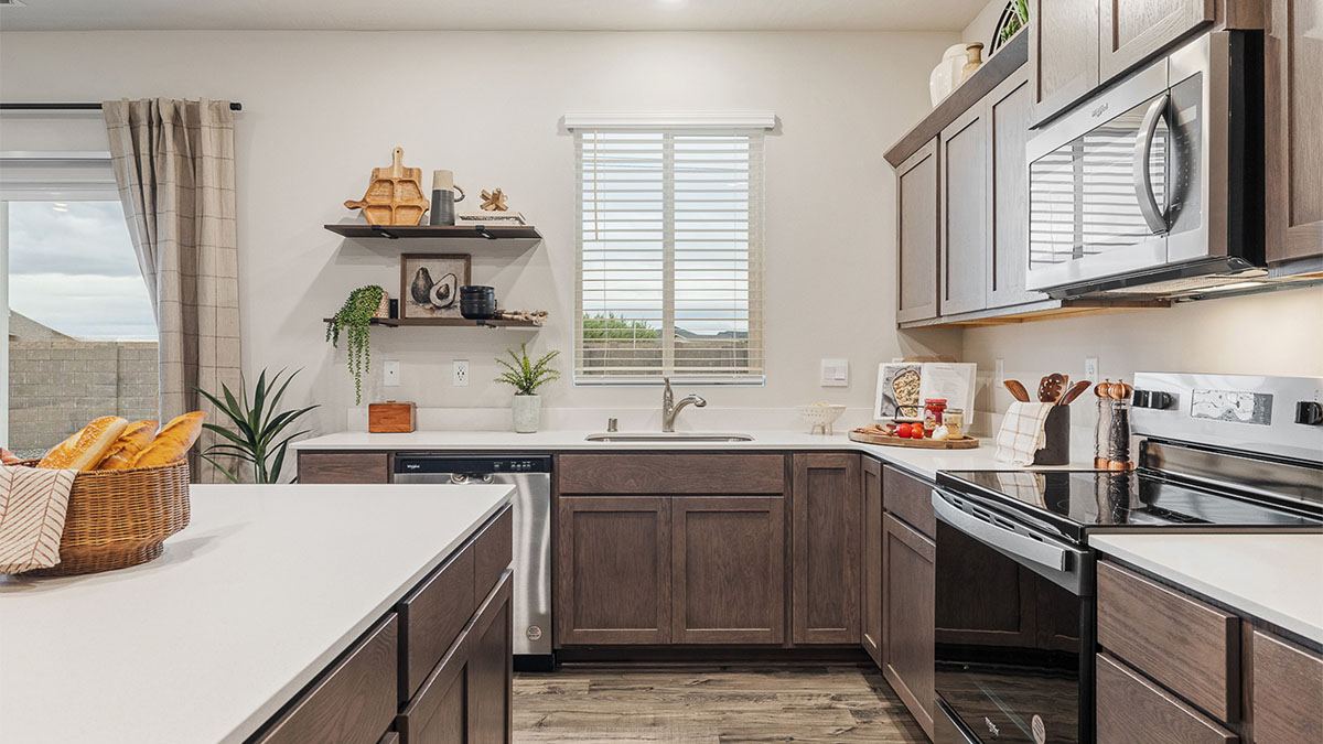 Kitchen with shaker cabinets, quartz counters, stainless steel appliances, pantry, and an island with a breakfast bar