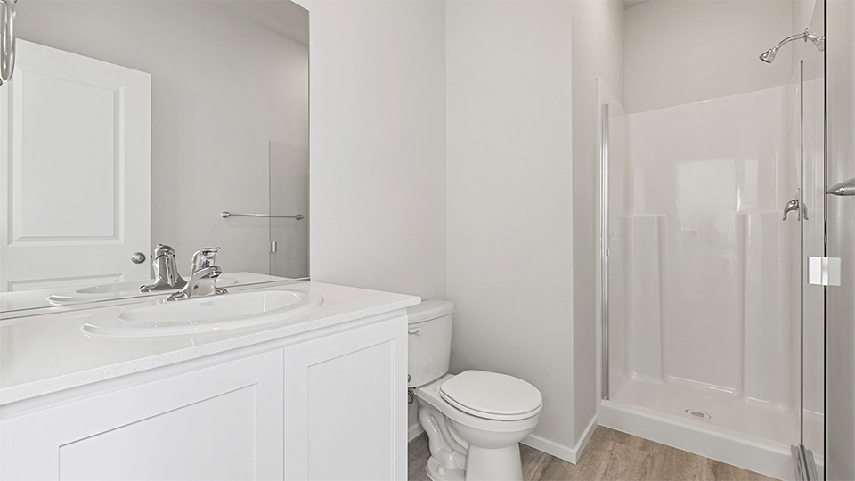 bathroom with quartz counters and a walk-in shower