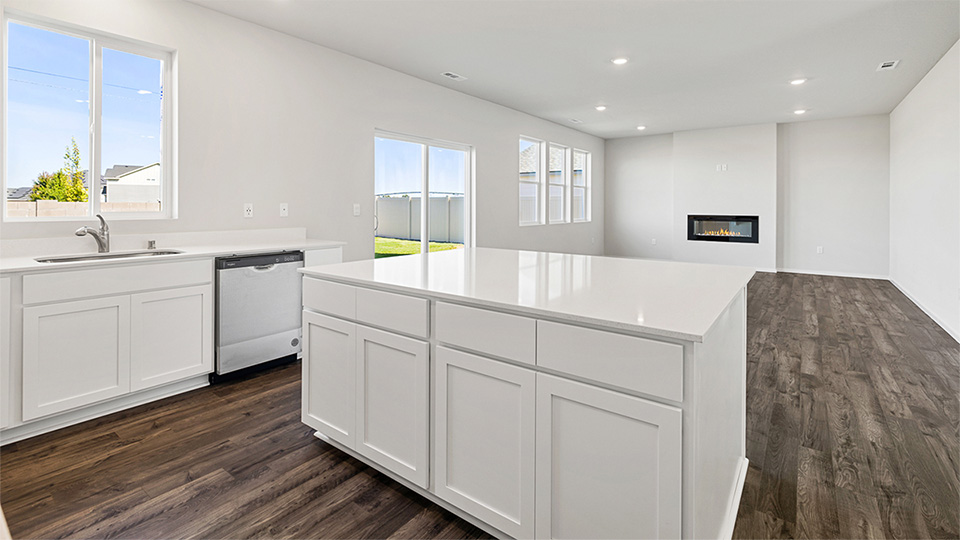 Kitchen with shaker cabinets, quartz counters, stainless steel appliances, pantry, and an island with a breakfast bar