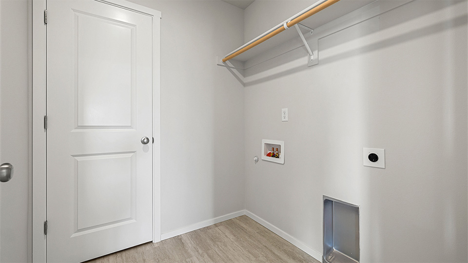 Laundry room with built-in shelves and washer and dryer hookups