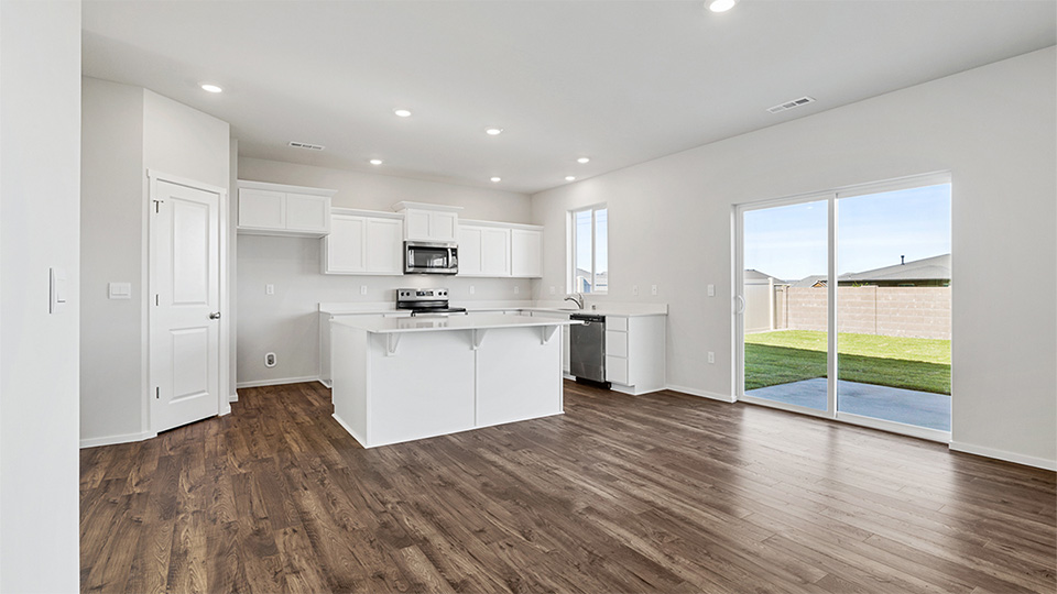 Kitchen with shaker cabinets, quartz counters, stainless steel appliances, pantry, and an island with a breakfast bar