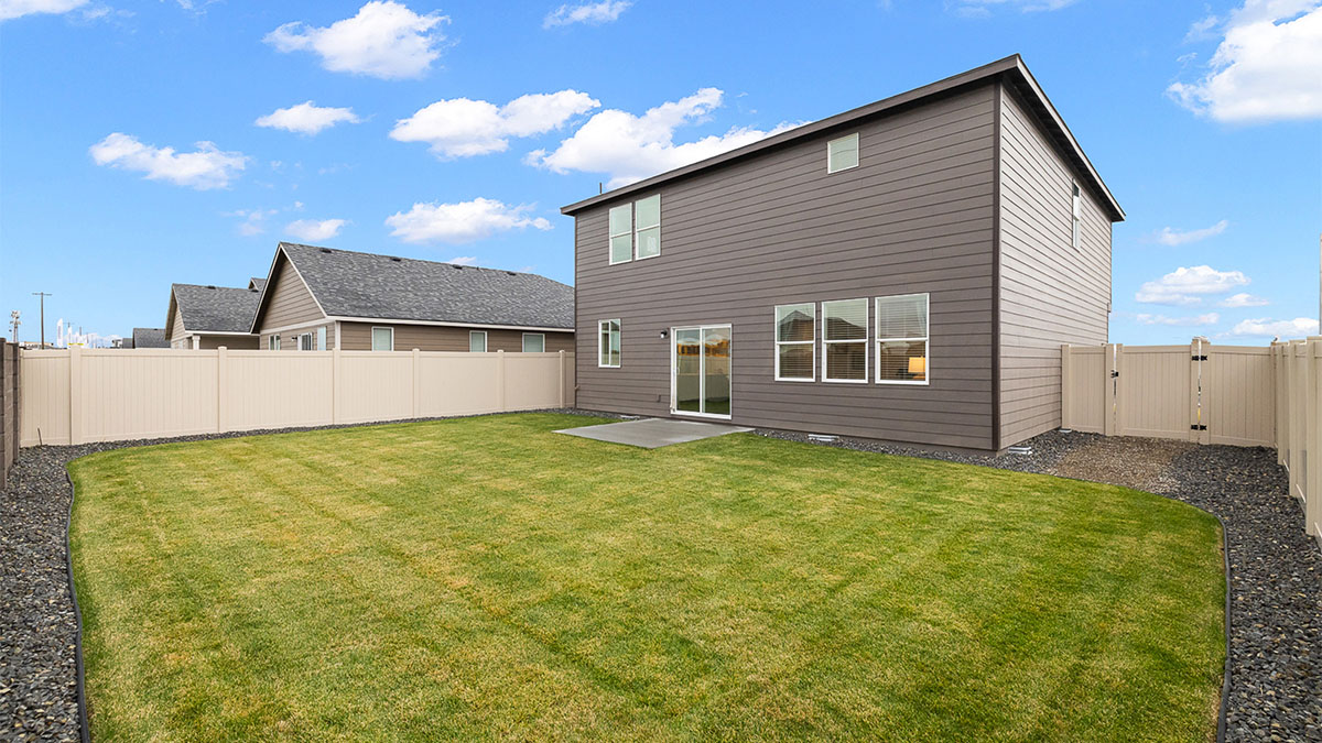 backyard with sod and vinyl plank fence and patio