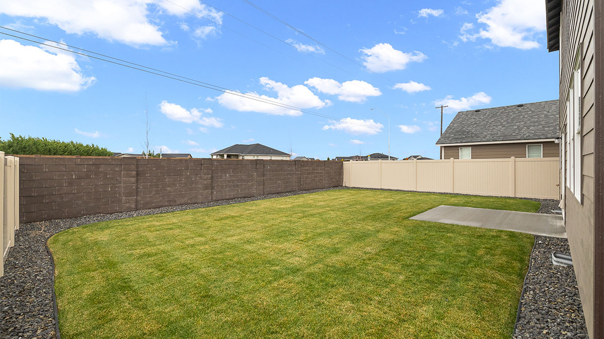 backyard with sod and vinyl plank fence and patio