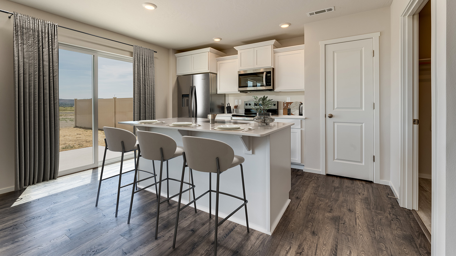 Kitchen with shaker cabinets, quartz counters, stainless steel appliances, pantry, and an island with a breakfast bar