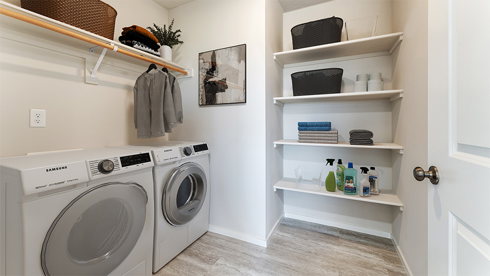 Laundry room with built-in shelves and washer and dryer hookups