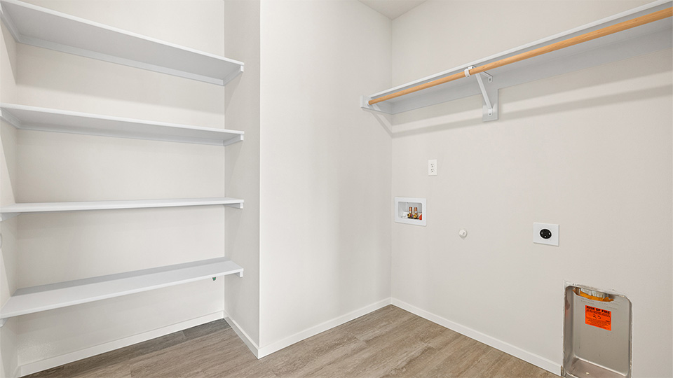 Laundry room with built-in shelves and washer and dryer hookups