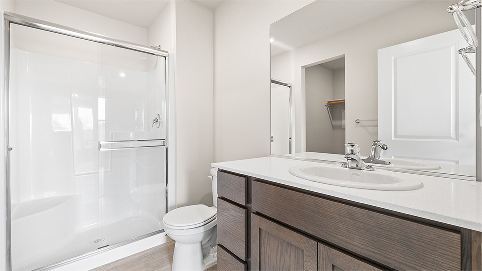 Primary bathroom with quartz counters and a walk-in shower