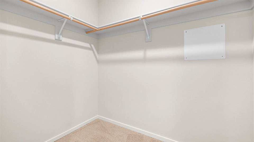 Primary bedroom walk-in closet with built-in shelves