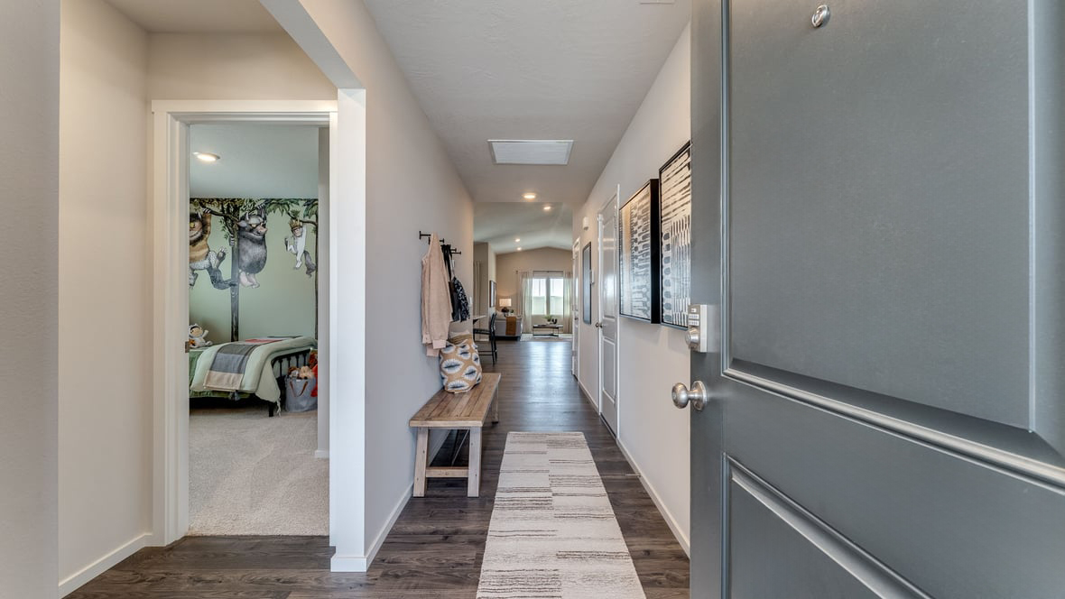 An entryway with premium laminate flooring, main level bedroom, and a full bathroom on the lower level.