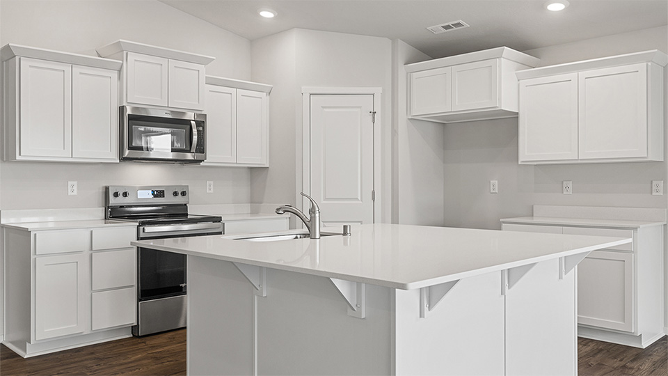 Kitchen with shaker cabinets, quartz counters, stainless steel appliances, pantry, and an island with a breakfast bar