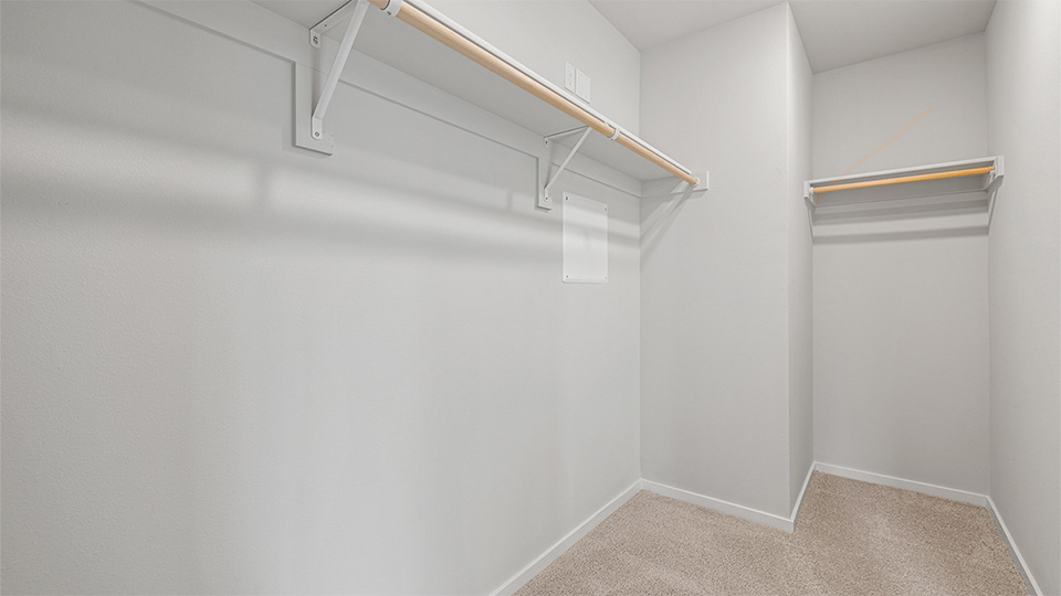 Primary bedroom walk-in closet with built-in shelves