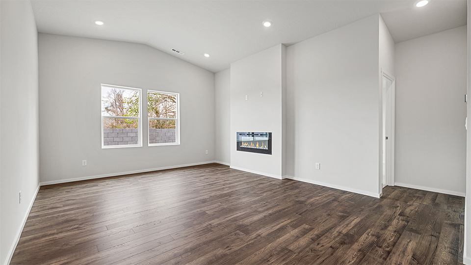 Great room with laminate flooring and an electric fireplace and vaulted ceilings