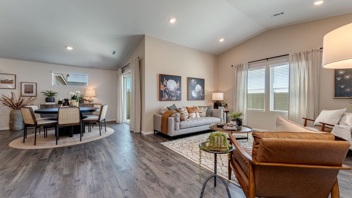 great room with an electric fireplace, vaulted ceilings, and premium laminate flooring