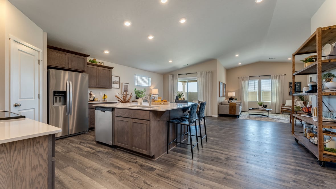 Kitchen with shaker cabinets, quartz counters, stainless steel appliances, pantry, and an island with a breakfast bar
