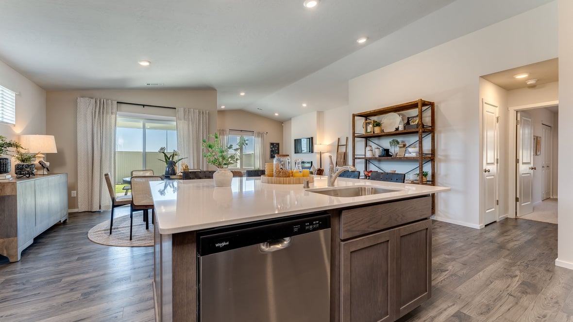 Kitchen with shaker cabinets, quartz counters, stainless steel appliances, pantry, and an island with a breakfast bar