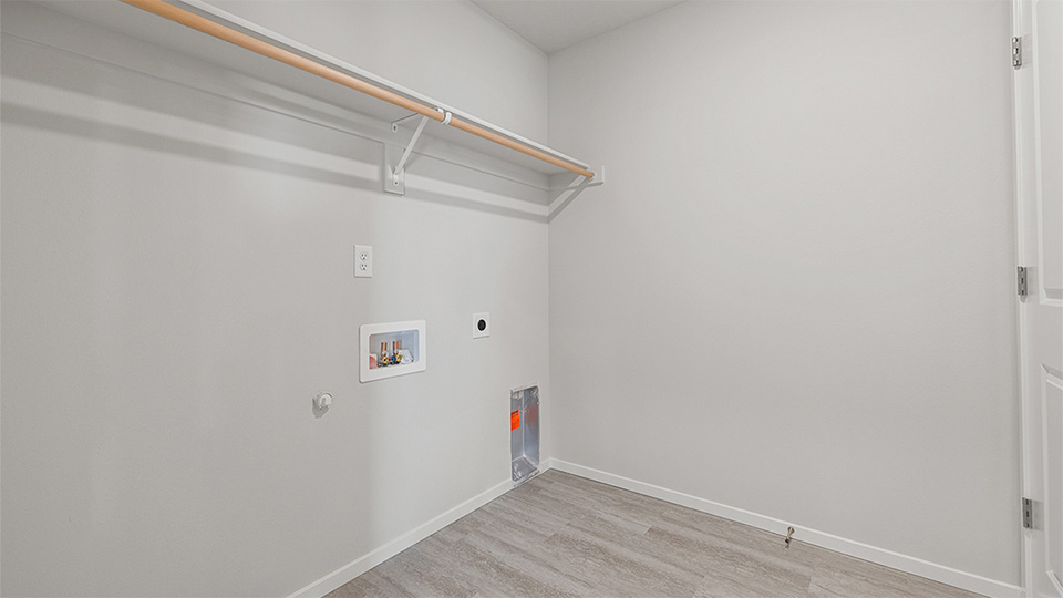 Laundry room with built-in shelves and washer and dryer hookups
