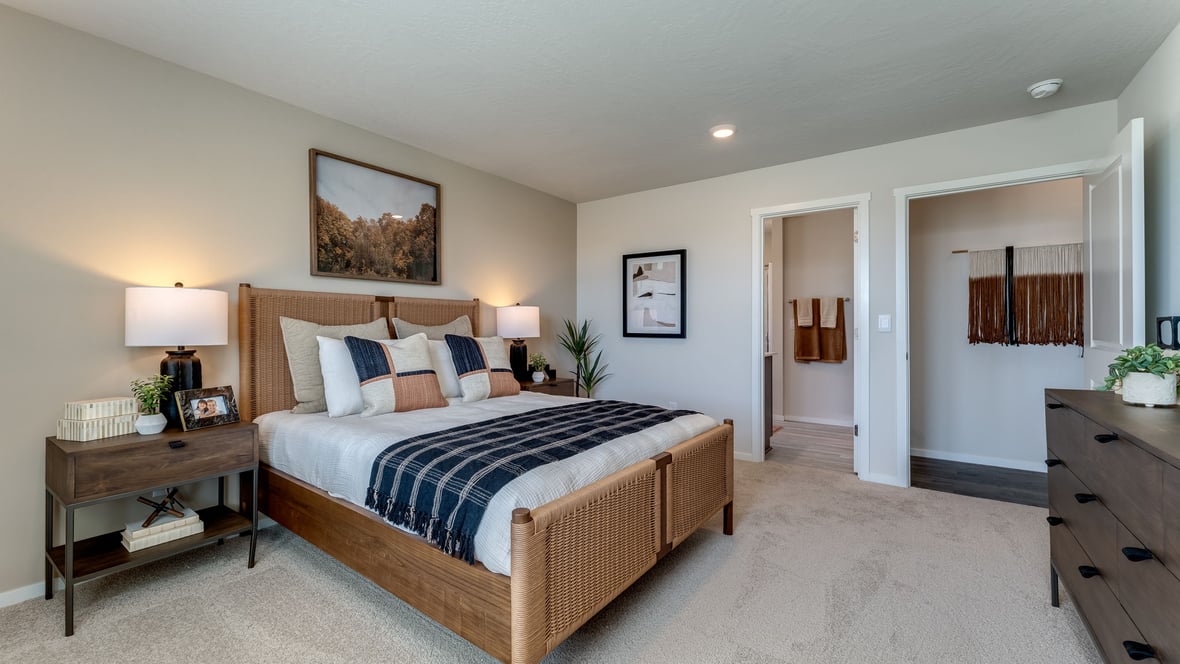 primary bedroom with wall-to-wall carpet, queen sized bed, and large dresser
