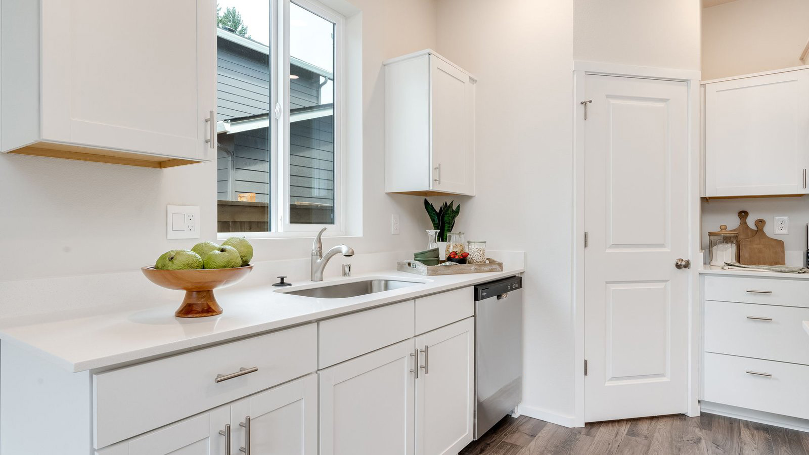 Kitchen with shaker cabinets, quartz counters, stainless steel appliances, pantry, and an island with a breakfast bar