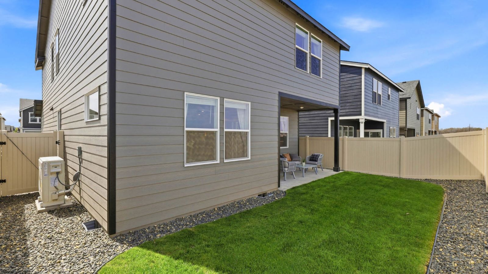 fully fenced backyard with sod lawn and a patio
