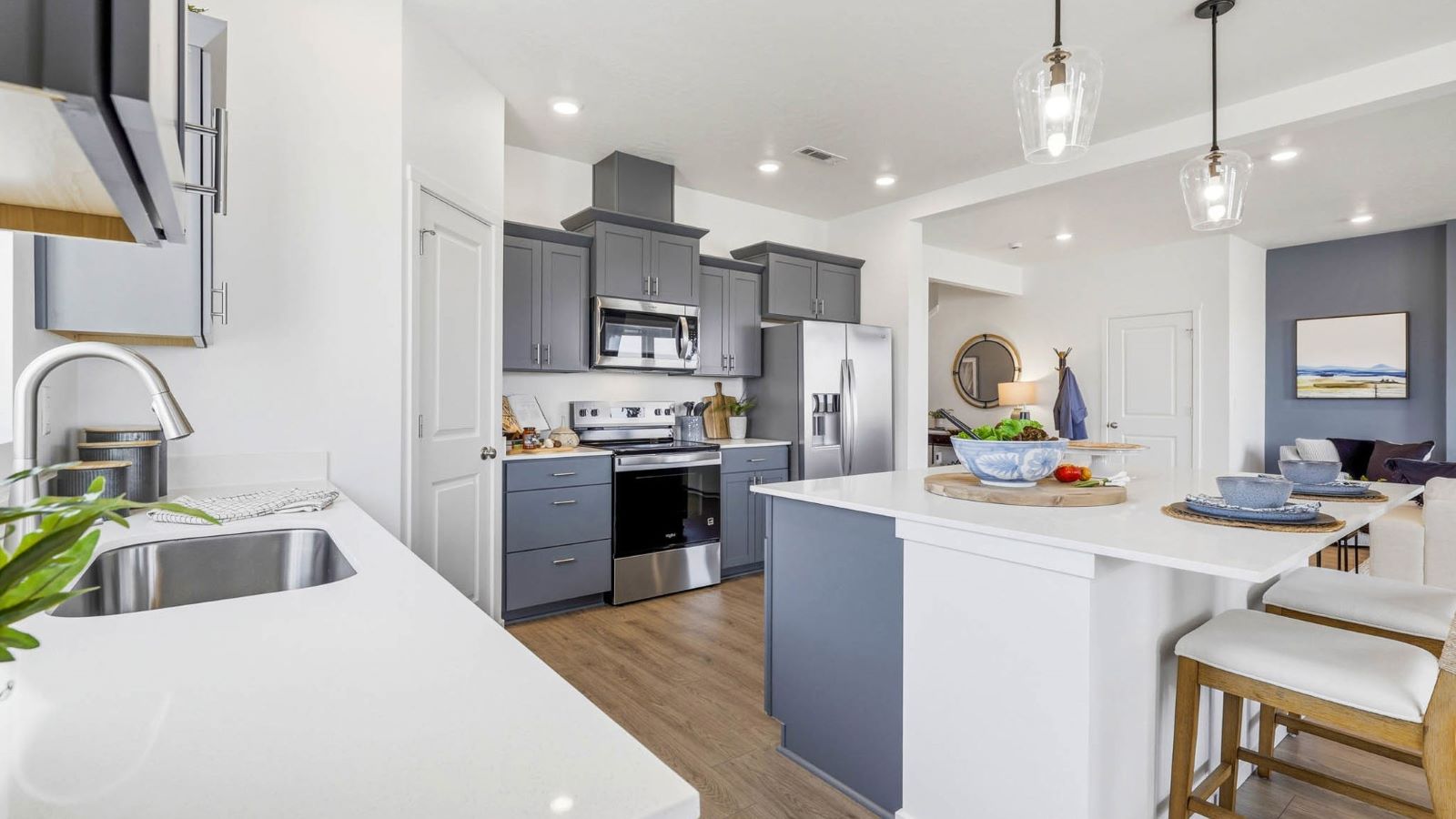 Kitchen with shaker cabinets, quartz counters, stainless steel appliances, pantry, and an island with a breakfast bar
