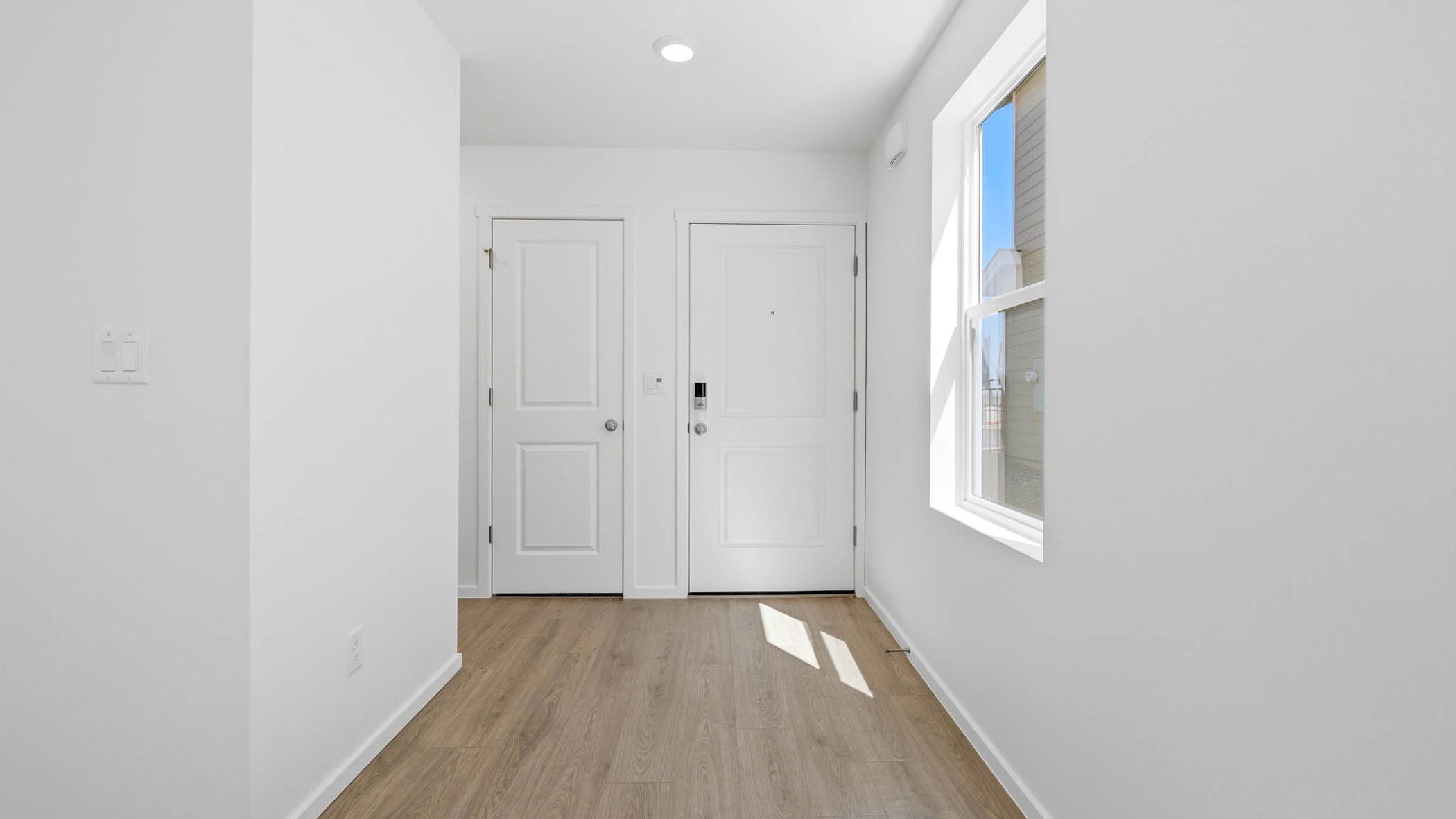 Entryway with a coat closet and laminate flooring