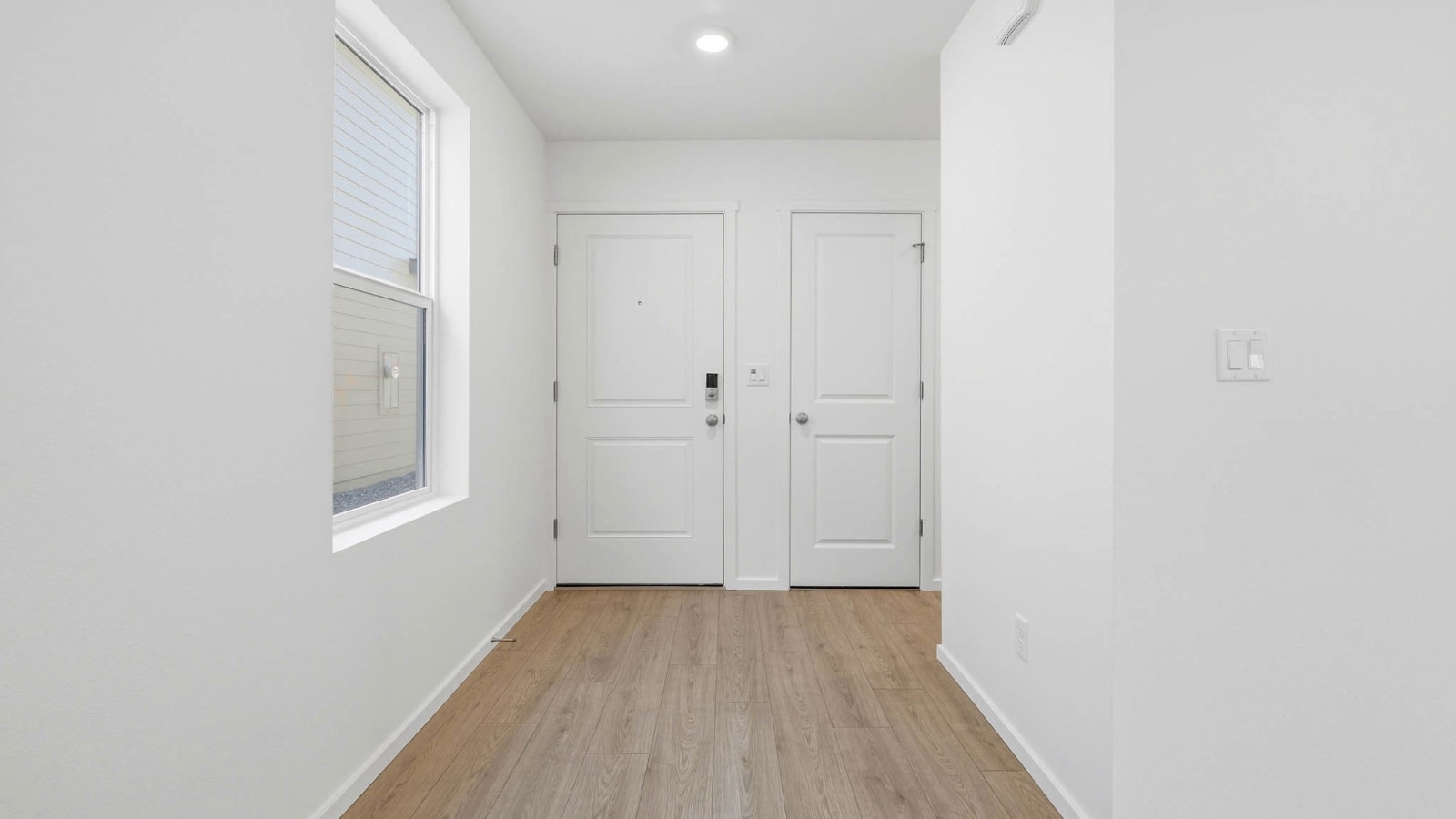 Entryway with a coat closet and laminate flooring