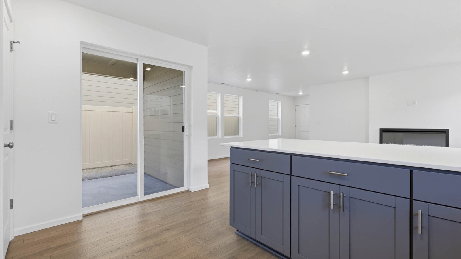 U-shaped kitchen with shaker cabinets, quartz counters, stainless steel appliances, pantry, and a breakfast bar