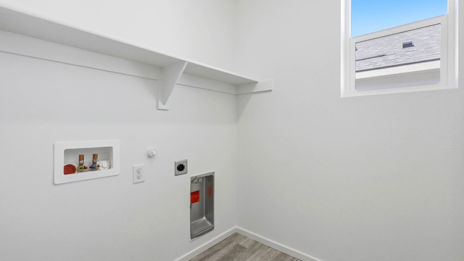 Laundry room with built-in shelves and washer and dryer hookups