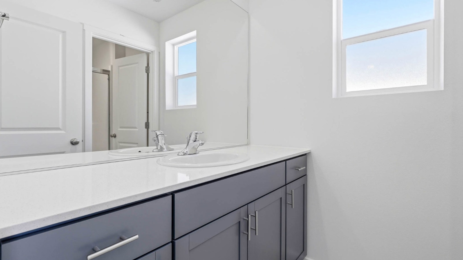 Primary bathroom with quartz counters and a walk-in shower
