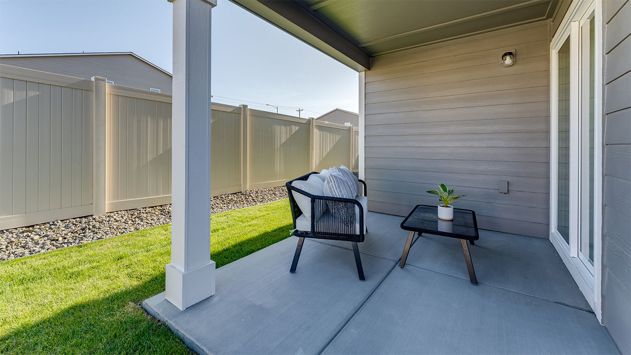 backyard with sod and vinyl plank fence and covered patio