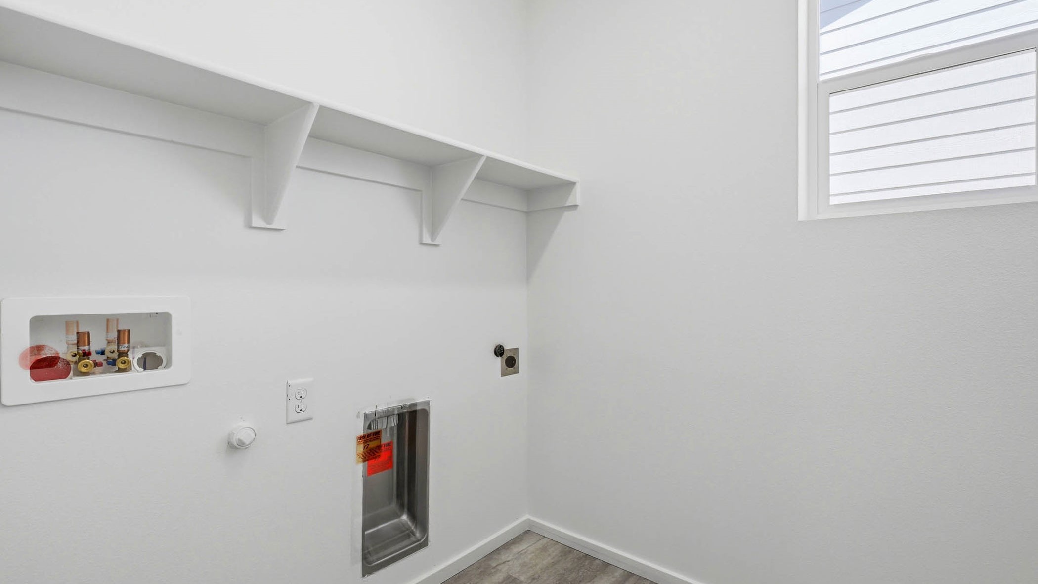Laundry room with built-in shelves and washer and dryer hookups