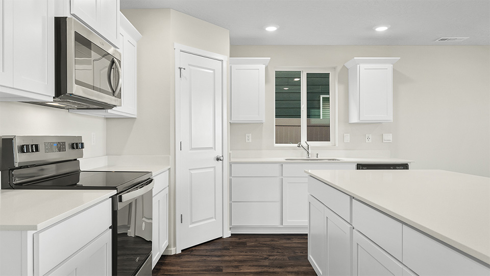 Kitchen with shaker cabinets, quartz counters, stainless steel appliances, pantry, and an island with a breakfast bar