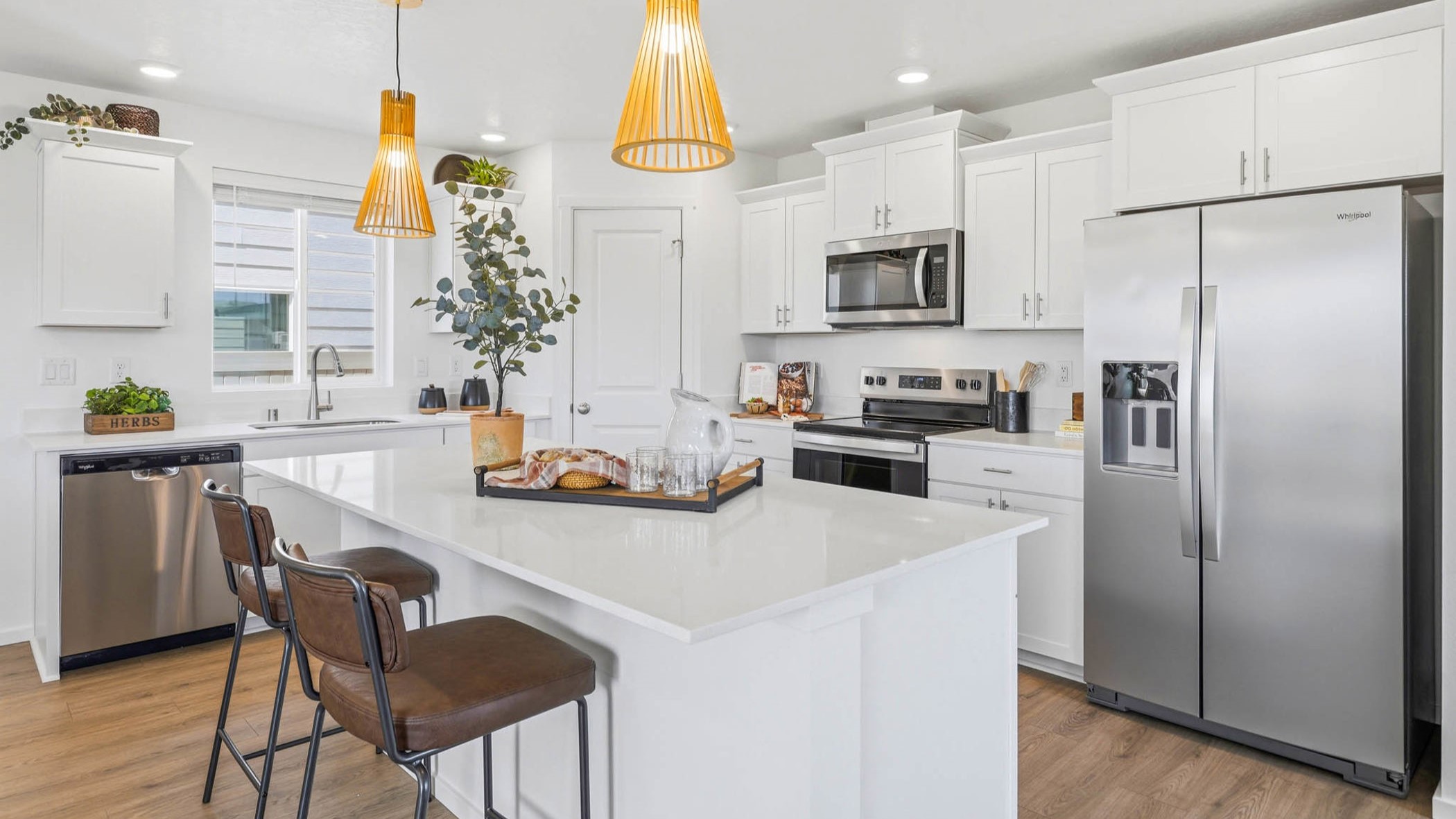 Kitchen with shaker cabinets, quartz counters, stainless steel appliances, pantry, and an island with a breakfast bar