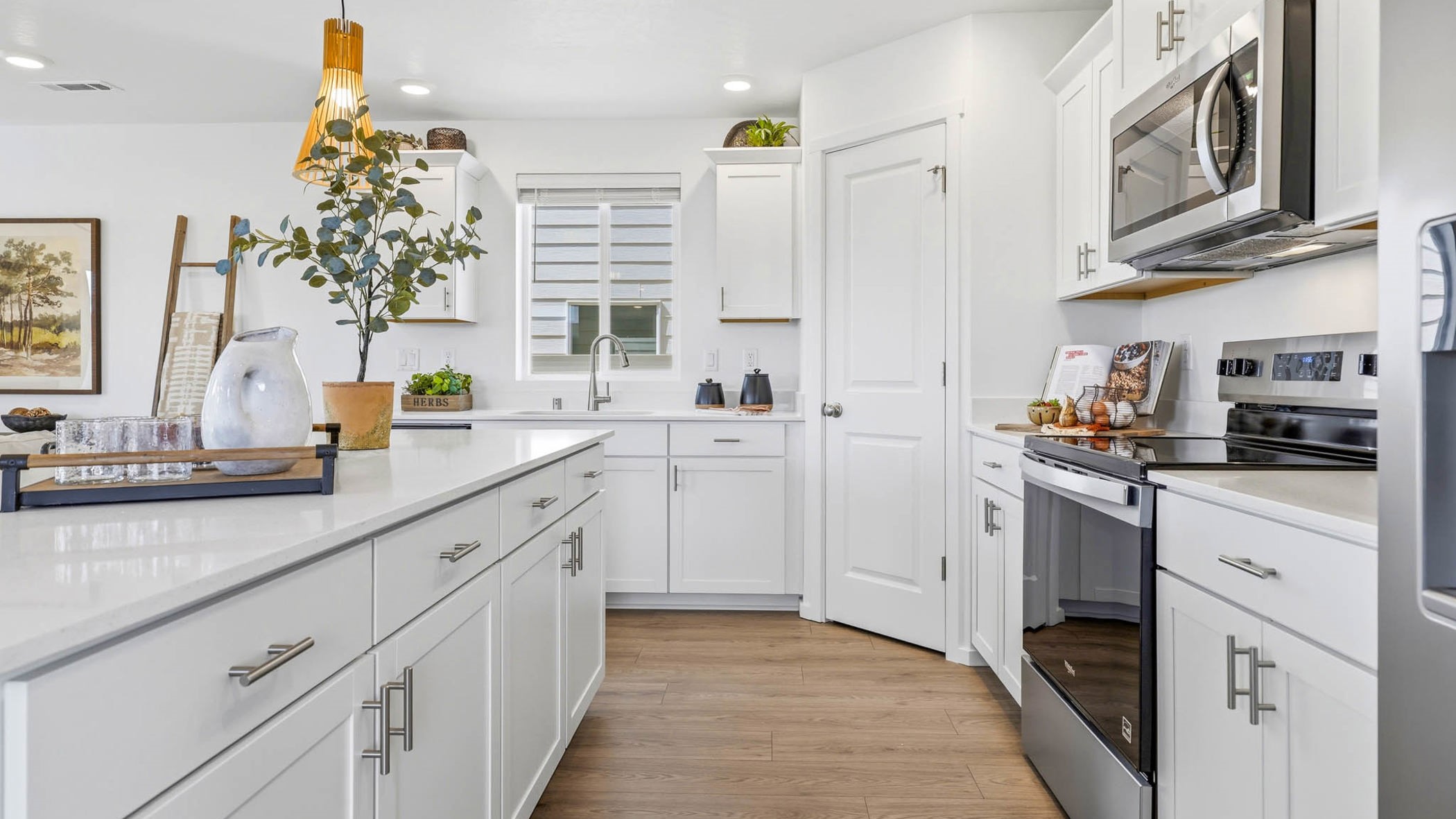 Kitchen with shaker cabinets, quartz counters, stainless steel appliances, pantry, and an island with a breakfast bar