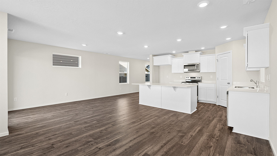 Kitchen with shaker cabinets, quartz counters, stainless steel appliances, pantry, and an island with a breakfast bar
