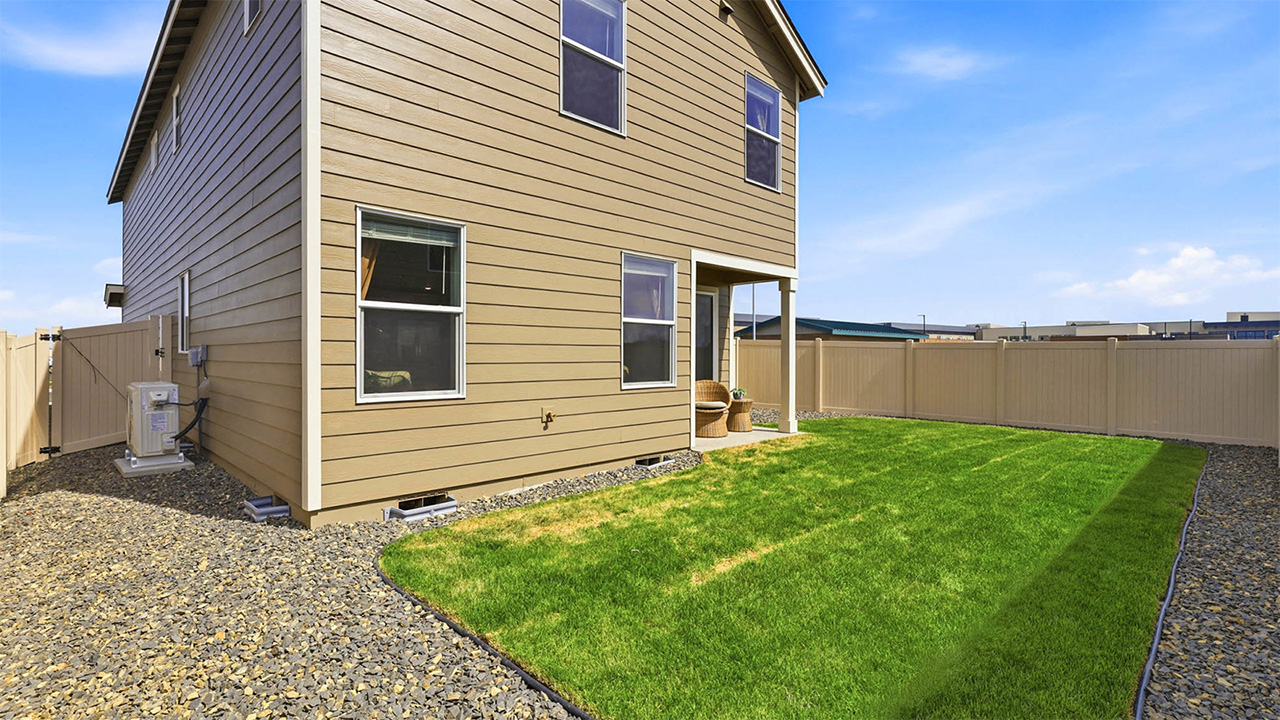 backyard with sod and vinyl plank fence and covered patio