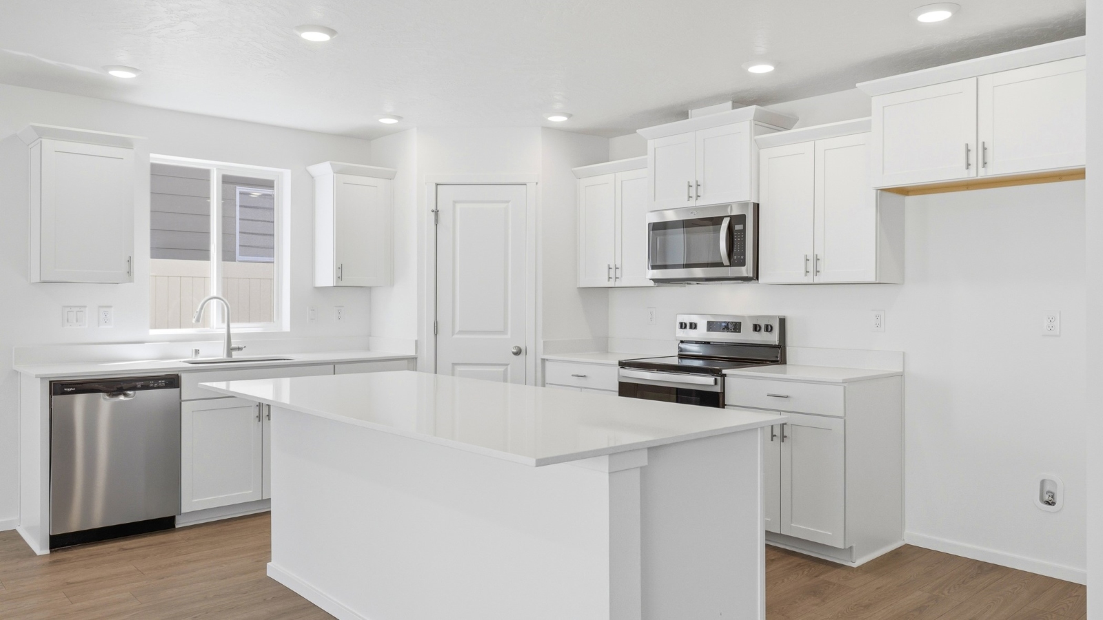 Kitchen with shaker cabinets, quartz counters, stainless steel appliances, pantry, and an island with a breakfast bar
