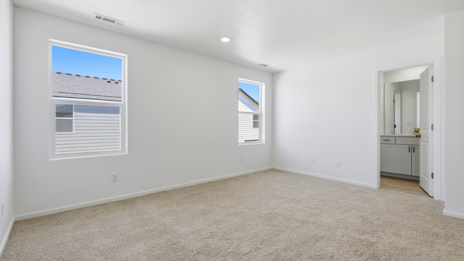 Primary bedroom with wall-to-wall carpet, a walk-in closet and an attached bathroom
