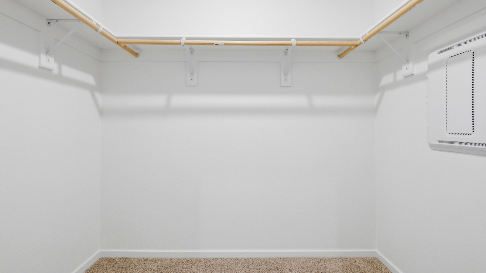 Primary bedroom walk-in closet with built-in shelves
