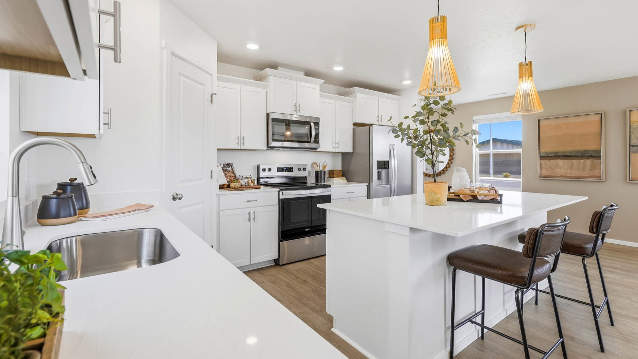 Kitchen with shaker cabinets, quartz counters, stainless steel appliances, pantry, and an island with a breakfast bar