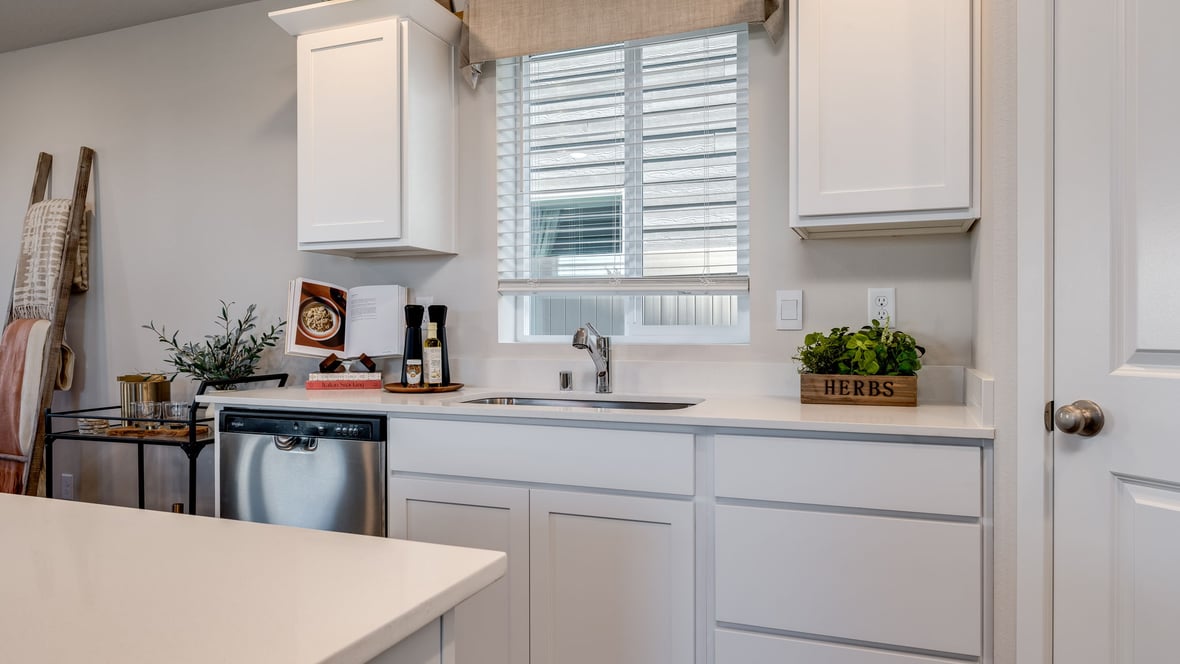 Kitchen with shaker cabinets, quartz counters, stainless steel appliances, pantry, and an island with a breakfast bar