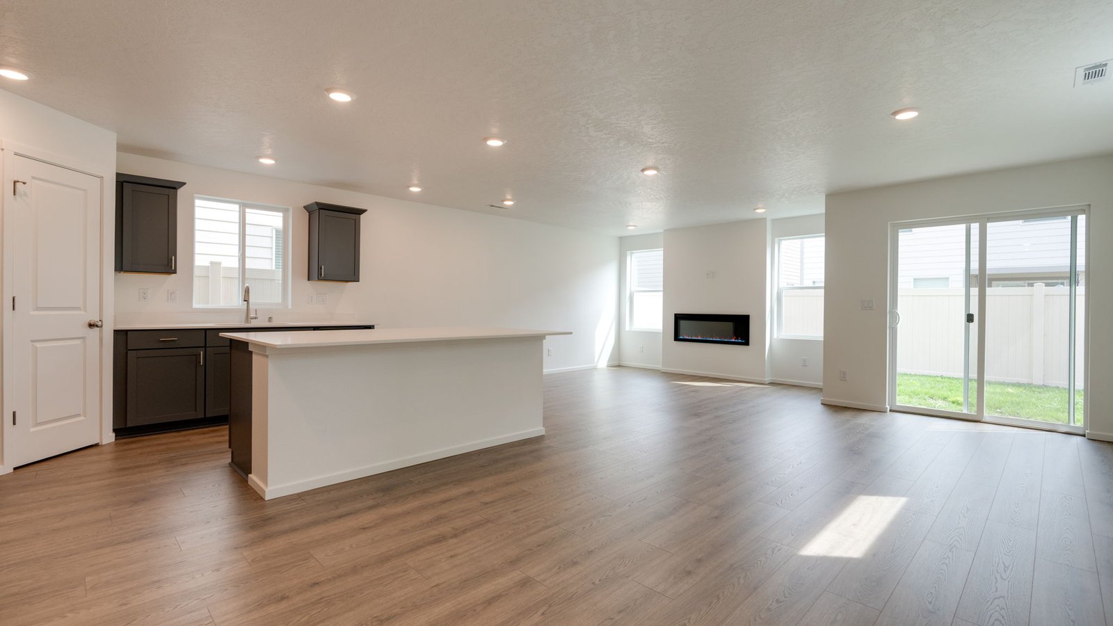 Kitchen with shaker cabinets, quartz counters, stainless steel appliances, pantry, and an island with a breakfast bar
