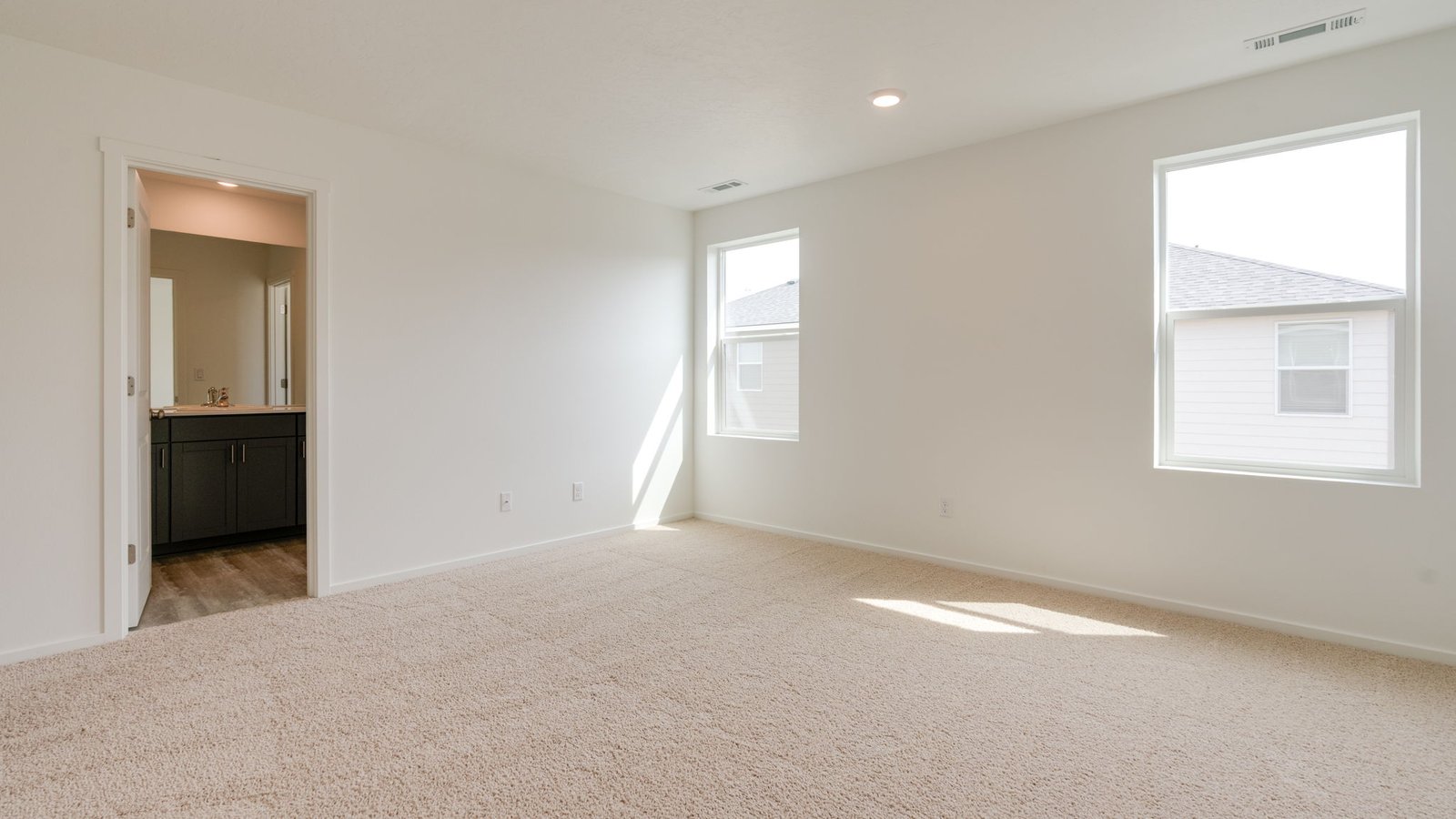 Primary bedroom with wall-to-wall carpet, a walk-in closet and an attached bathroom